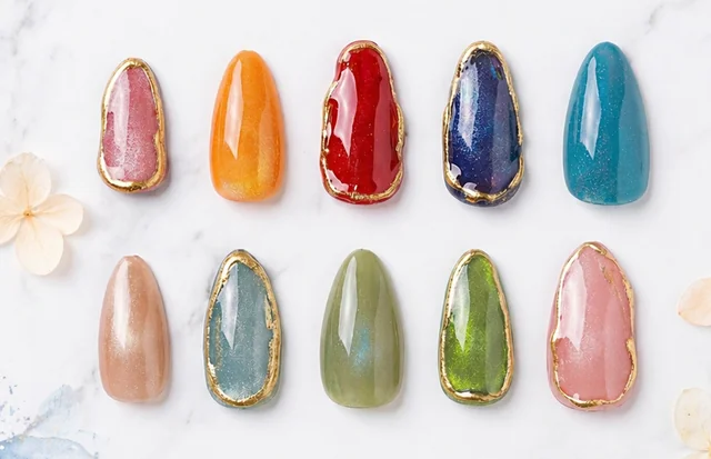 Colorful press-on nails with shimmering finishes and gold-edged designs